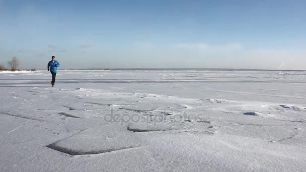 Hombre Con Una Chaqueta Azul Cruzando Hielo Río Congelado Reservoir — Vídeos de Stock