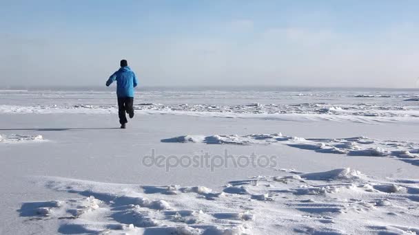 凍った川 貯水池 ロシアの氷の上を実行している青いジャケットの男 — ストック動画