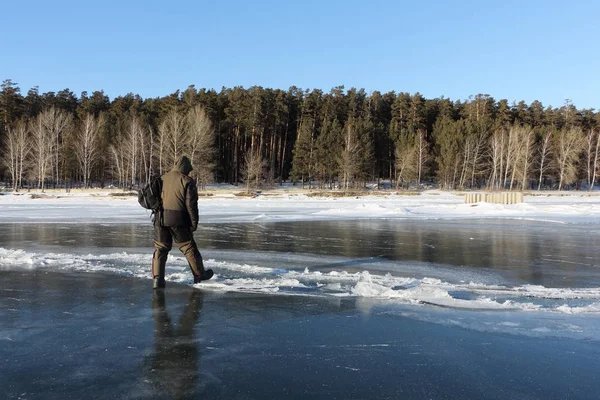 Man kliva över en spricka på tunn is en frusen flod — Stockfoto