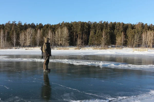 Man stående stående på tunna isen av en frusen flod — Stockfoto