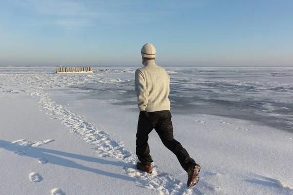 Зрелый человек бежит по льду замерзшей реки — стоковое фото
