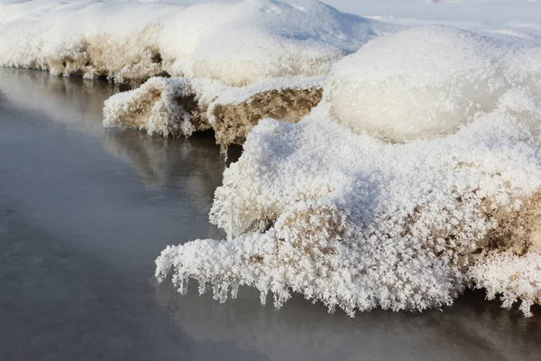 Icicli in rime su una pietra su un fiume ghiacciato — Foto Stock