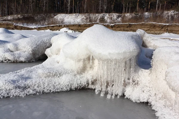 Ijspegels in rime op een steen op een ijskoude rivier — Stockfoto