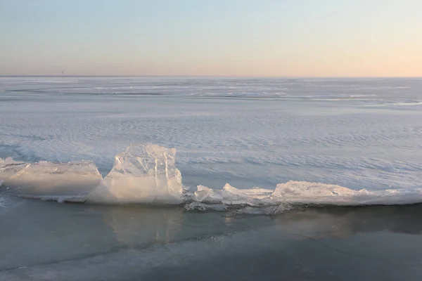 Трещины с кристаллами льда на замерзшей реке на закате, Обское водохранилище, Россия — стоковое фото