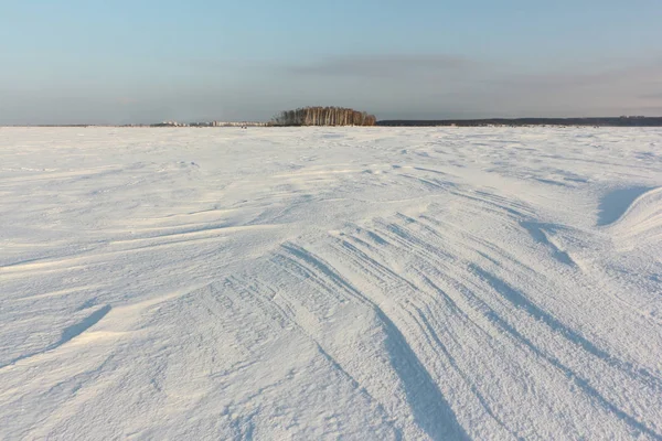 Opluchting besneeuwde oppervlak van de bevroren rivier bij dageraad — Stockfoto