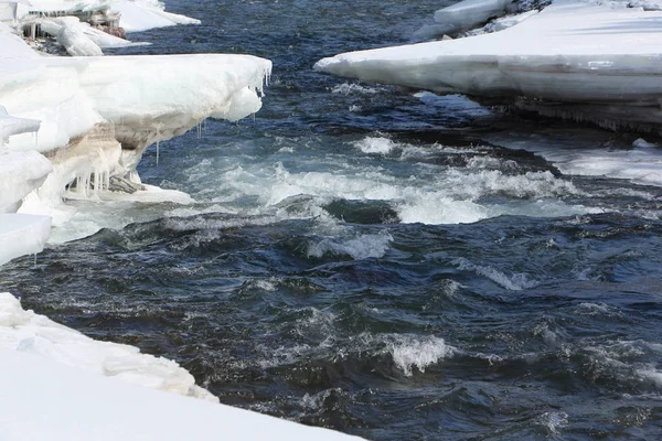 Stormy stream of water in the river amid melting ice — Stock Photo, Image