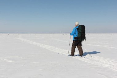 Adam t bir sırt çantası ile karlı bir nehir üzerinde Kayak
