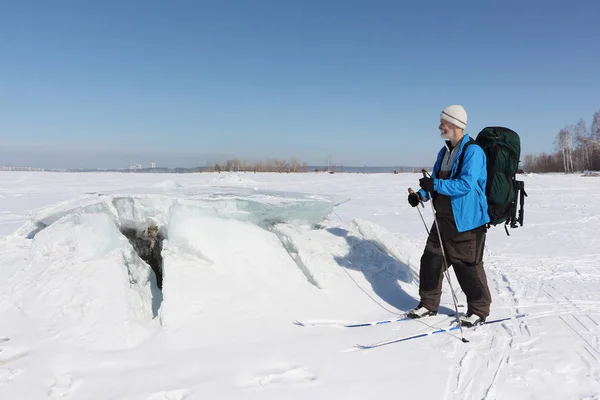 Man op ski kijken naar het ijs breken op de op de rivier, Ob Reservoir, Rusland — Stockfoto