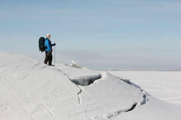 El hombre con una mochila está esquiando en el hielo del río congelado, embalse de Ob, Rusia —  Fotos de Stock
