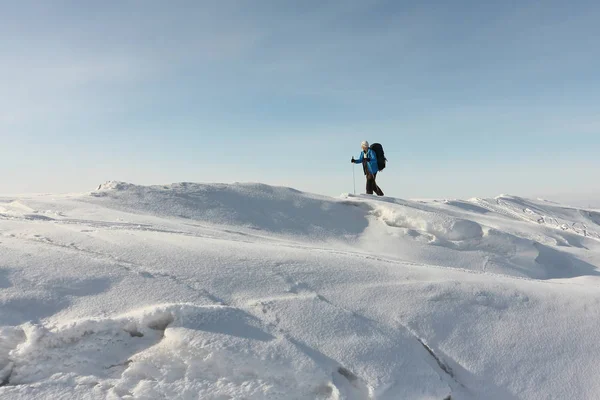 Homem de casaco azul com mochila está esquiando no gelo — Fotografia de Stock