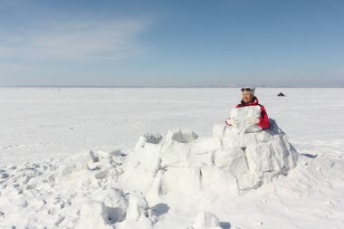 Mutlu kadın kırmızı bir ceket bir Eskimo kar glade üzerinde bina 