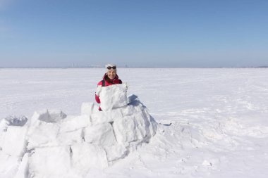 Mutlu kadın kırmızı bir ceket bir Eskimo kar glade üzerinde bina