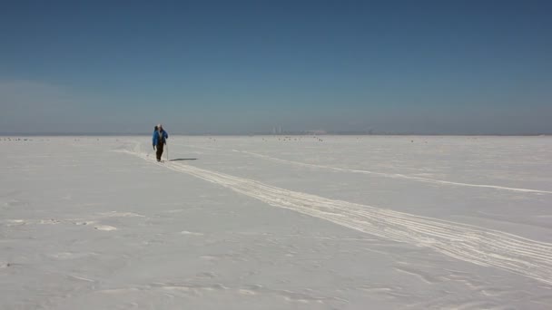 穿着蓝色夹克的男人在结冰的河上滑雪 — 图库视频影像