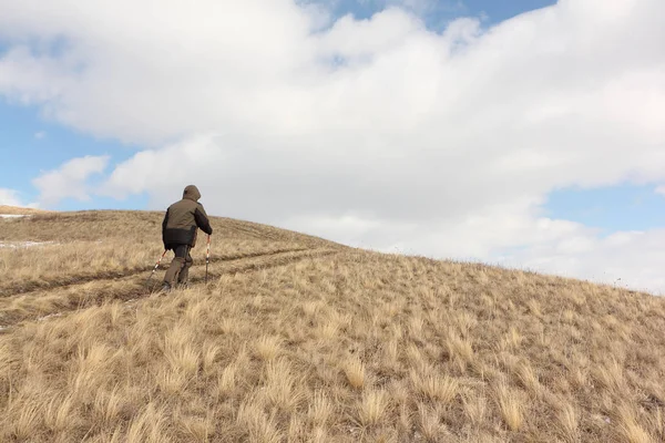 Nordic Walking - взрослый мужчина, поднимающийся на вершину горы — стоковое фото