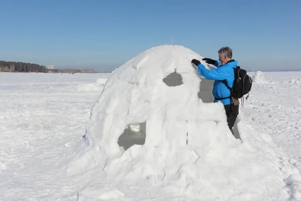冬天在下雪的水库上建造一座冰屋的人 — 图库照片