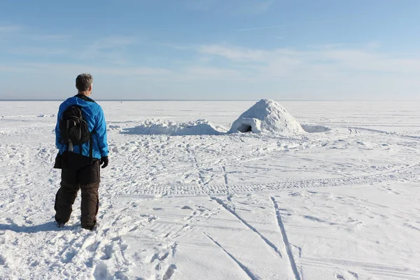 Man die door een iglo op het bevroren reservoir in de winter — Stockfoto