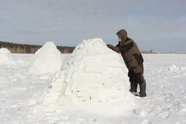 El hombre construyendo un iglú de bloques de nieve en el invierno — Foto de Stock