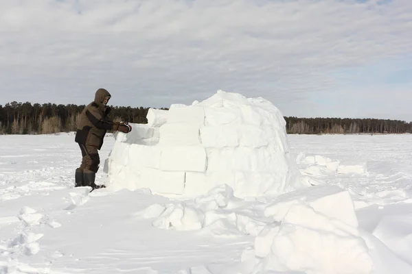 El hombre construyendo un iglú de bloques de nieve en el invierno —  Fotos de Stock