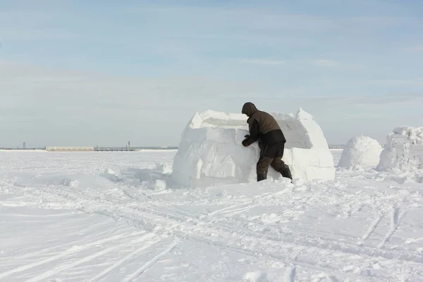 Homem construindo um iglu de blocos de neve no inverno — Fotografia de Stock