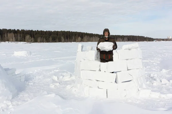 Homme construisant un igloo à partir de blocs de neige en hiver — Photo