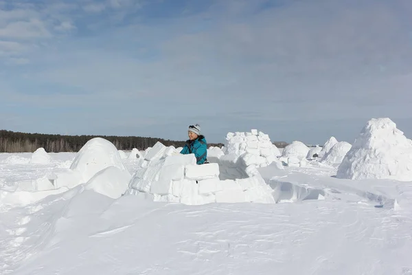 Mujer feliz en ropa de abrigo construyendo un iglú en un claro de nieve —  Fotos de Stock