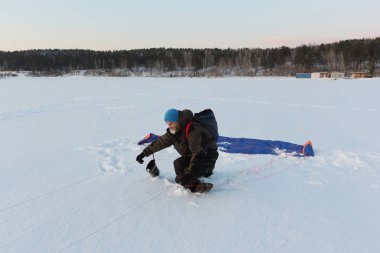 Rusya Novosibirsk 'te bir uçurtmanın yanında gevşeyen bir adam.