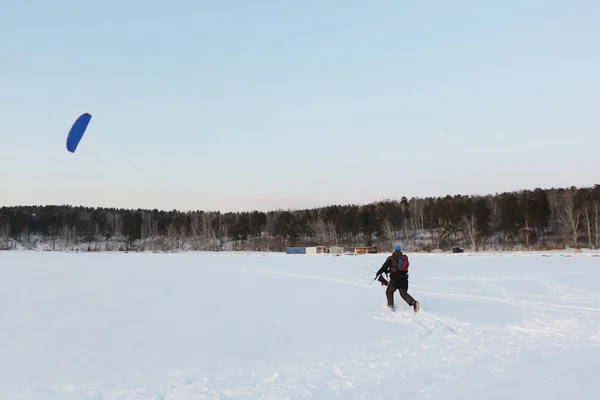 Man controleert een blauwe vlieger in de winter, Novosibirsk, Rusland — Stockfoto