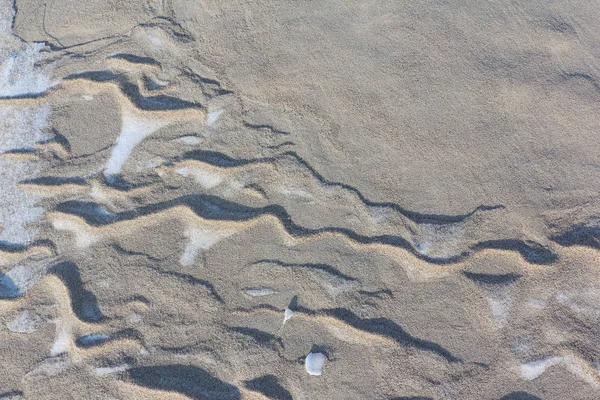 Neve e sabbia ghiacciata lungo il fiume, sfondo naturale — Foto Stock