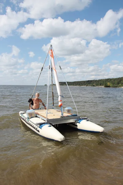 Man lowering catamaran into river, Novosibirsk, Russia — Stockfoto