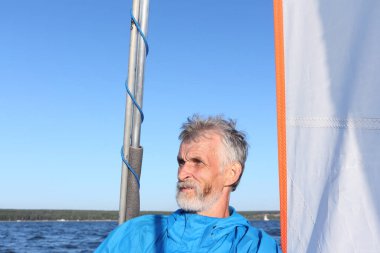 Man sternly looking away amid sail and sky, Novosibirsk, Russia