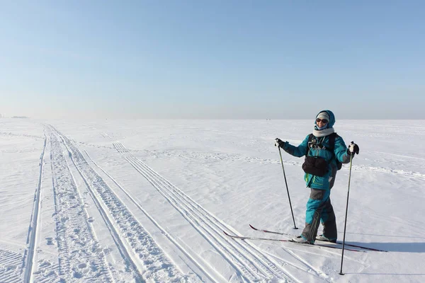 Szczęśliwa kobieta z plecakiem na nartach na zamarzniętej rzece, Nowosybirsk, Rosja — Zdjęcie stockowe