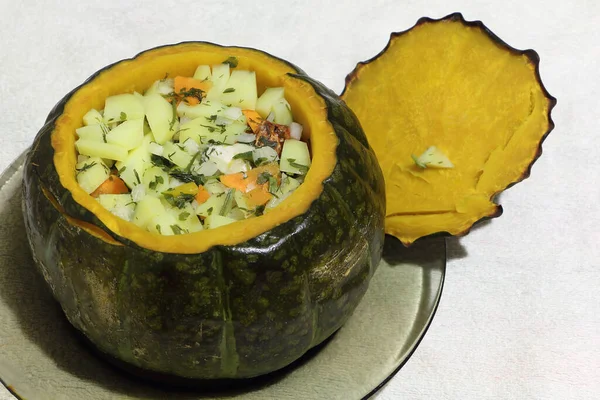 Ready green  pumpkin stuffed with vegetables on a plate