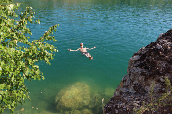 Man lying motionless on his back on the water surface of a freshwater lake, Marmara Lake, Novosibirsk Region, Russia