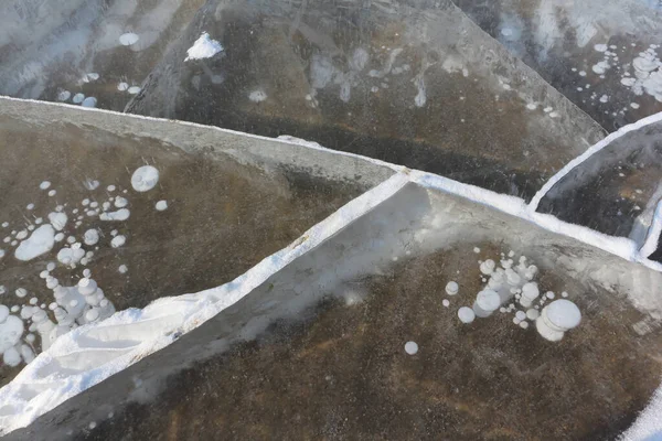 Cracks and frozen bubbles on a river surface in winter, Ob River, Novosibirsk, Russia