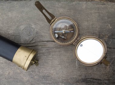 Teleskop ve pusula bir ahşap zemin üzerine üstten görünüm