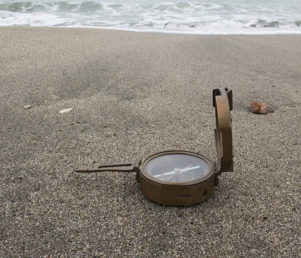 Vintage bronzen kompas op de achtergrond van de zee op het zand — Stockfoto