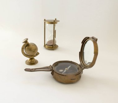 Küre, pusula ve pirinç beyaz bir arka plan üzerinde kum saati