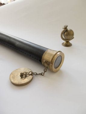 Background with a telescope and a globe of brass on a white back