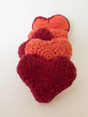 Örgü yün kalpler beyaz zemin üzerine kırmızı ve turuncu