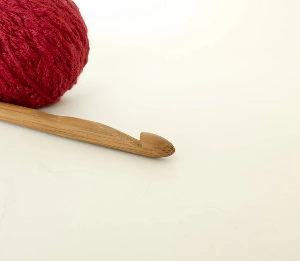 Crochet en bois avec une boule de laine sur blanc — Photo
