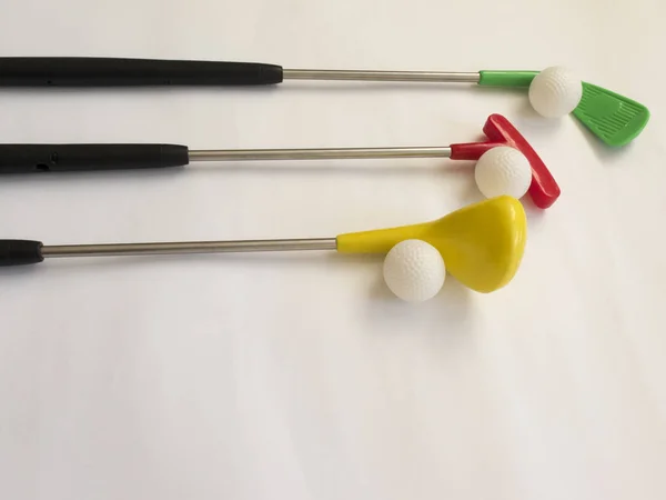 Trzy kolorowe kluby golfowe z kulkami na białym tle — Zdjęcie stockowe