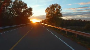 Kurallara uymaya görünümü perspektif bir araba sürüş bir yolda günbatımında - bin Adaları Parkway, Kanada. Gyro stabilize kamera arabanın kaputu monte edilmiştir. Zaman atlamalı