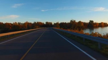 Kurallara uymaya görünümü perspektif bir araba sürüş bir yolda günbatımında - bin Adaları Parkway, Kanada. Gyro stabilize kamera arabanın kaputu monte edilmiştir. Zaman atlamalı