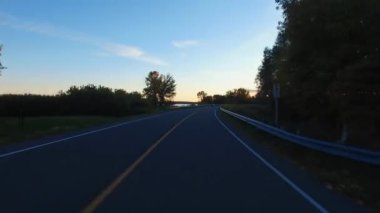 Kurallara uymaya görünümü perspektif bir araba sürüş bir yolda günbatımında - bin Adaları Parkway, Kanada. Gyro stabilize kamera arabanın kaputu monte edilmiştir. Zaman atlamalı