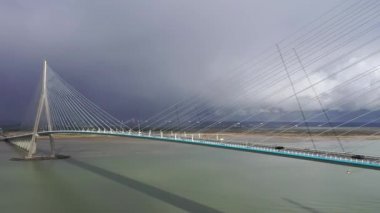 Fransa, Avrupa 'daki bir asma köprüde uçan araba ve kamyon trafiğinin hava görüntüsü. Pont de Normandy, Fransa 'nın kuzeyindeki büyük asma köprü Seine Nehri' ni gökkuşağı, Normandiya, Fransa 'da bulutlu bir gökkuşağı ile geçen köprü..