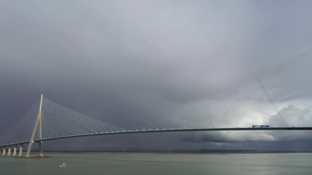 在漆黑的天空前 有卡车来往的公路桥 法国北部的一座巨大的悬索桥 诺曼底桥 横跨塞纳河 面对着乌云密布的天空 有彩虹 法国诺曼底 — 图库视频影像