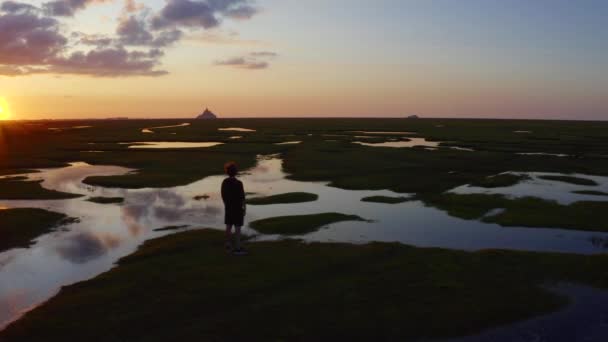 Хлопець Стоїть Луках Перед Монт Сен Мішелем Дивиться Захід Сонця — стокове відео