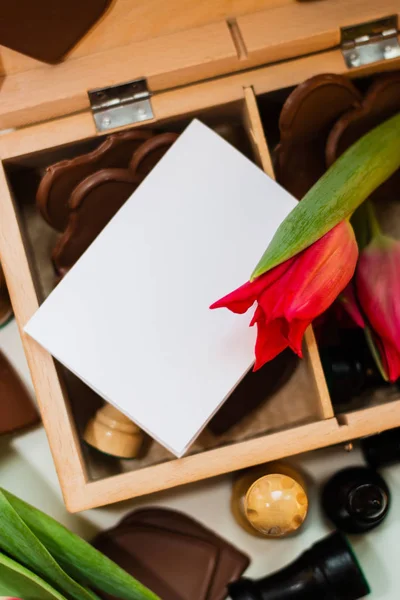 Ramo de tulipanes rojos, corazones de chocolate y ajedrez — Foto de Stock