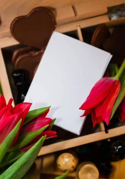 Ramo de tulipanes rojos, corazones de chocolate y ajedrez — Foto de Stock