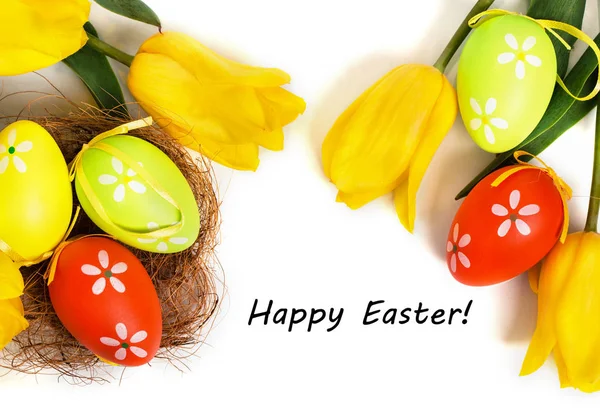 Húsvét színes tojások sárga tulipánok — Stock Fotó
